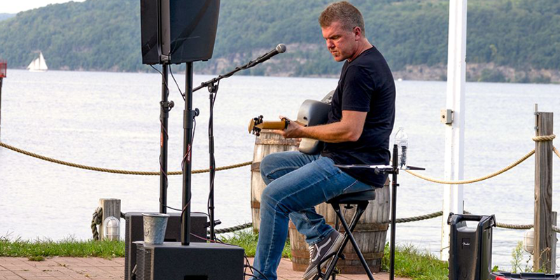 Tremayne Harer playing live music next to the lake.