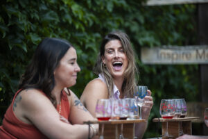 2 Girls laughing and enjoying a wine flight outside at Hazlitt Red Cat Cellars, Naples, NY.